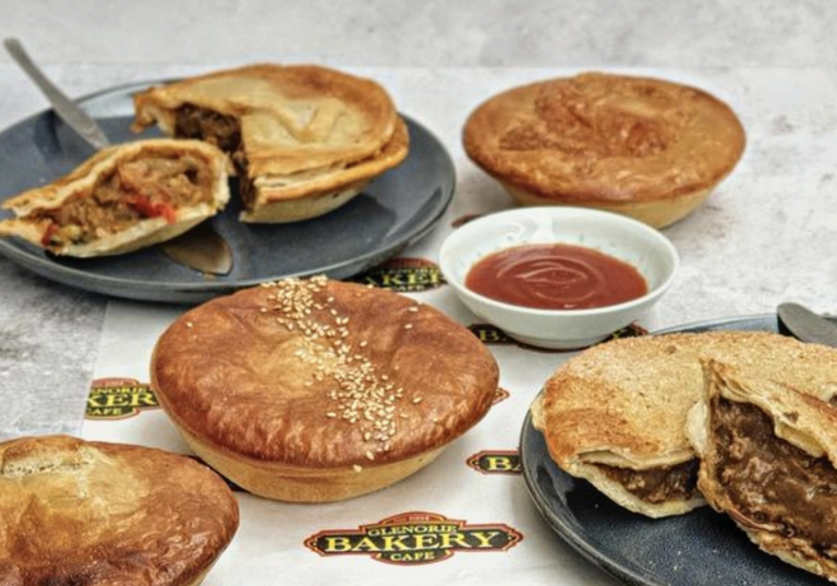 whole pies and halfed pies on a table with sauce