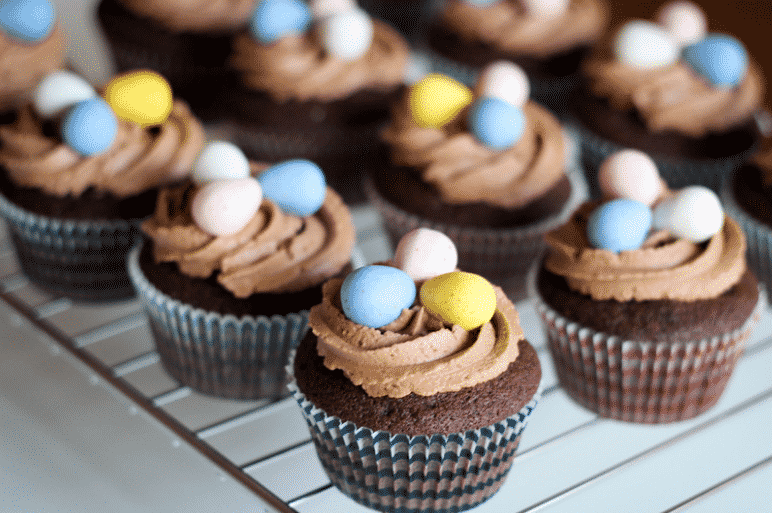 chocolate cupcakes with three easter eggs on top of the icing